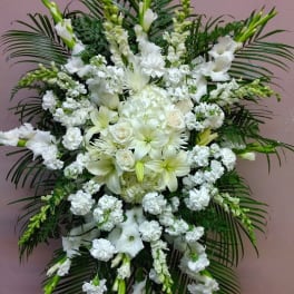 Large white funeral spray with lilies and roses