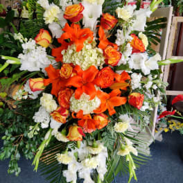 Large orange and white floral standing spray with roses and lilies