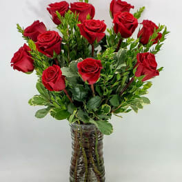 Red roses arranged in a clear glass vase