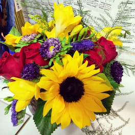 Bouquet of yellow sunflowers, red roses, and purple flowers