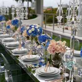 Long banquet table with blue and blush floral centerpieces and crystal candelabras