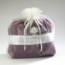 Purple spa robe packaged in a sheer white gift bag tied with ribbon
