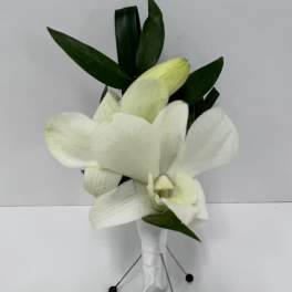 White cymbidium orchid boutonniere with wrapped stem and greenery backing