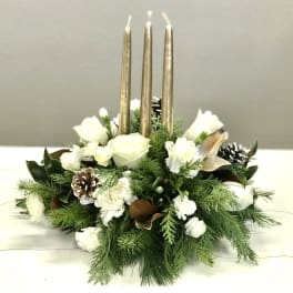 White floral centerpiece with gold taper candles and pinecones