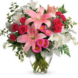 Pink lilies and roses in a clear glass vase