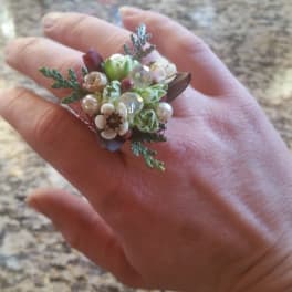 Small floral ring with white and green blossoms on a hand