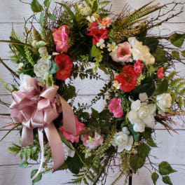 Heart-shaped floral wreath with pink and white flowers and a satin bow