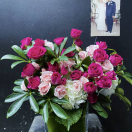 Pink and pale roses arranged in a clear square vase