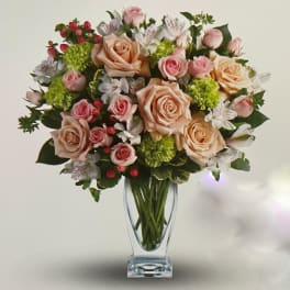 Bouquet of peach and pink roses in a clear glass vase