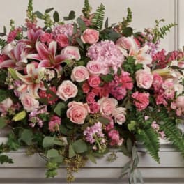 Large pink floral casket spray with roses and lilies