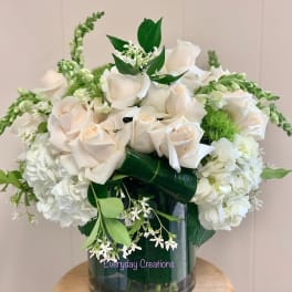 White roses and hydrangeas arranged in a glass vase