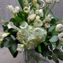 White floral arrangement with calla lilies, ranunculus, and hydrangea