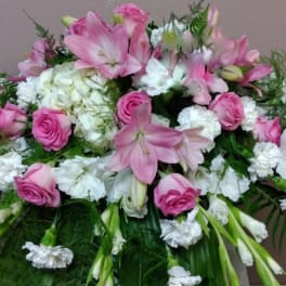 Pink and white floral spray with lilies, roses, and carnations