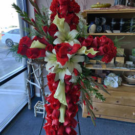 Large red and white floral cross arrangement on a stand
