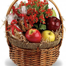 Basket of red flowers with apples and wrapped treats
