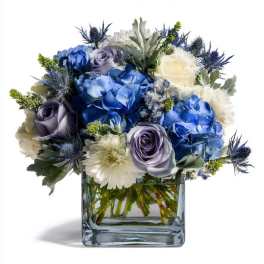 Blue and white flower arrangement in a square glass vase