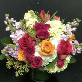 Mixed bouquet of roses, hydrangeas, and tulips in a vase