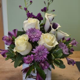 Bouquet of white roses, purple chrysanthemums, and calla lilies in a white box