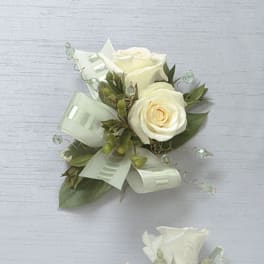 White rose boutonniere with pale ribbon and greenery