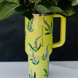 Yellow Stanley tumbler holding a leafy floral arrangement