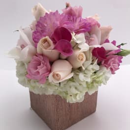 Pink and white floral arrangement in a square vase