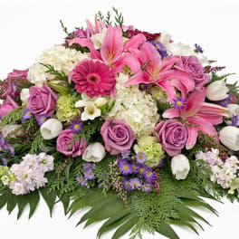 Pink and white floral spray with roses, lilies, and daisies