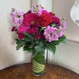 Pink and red mixed bouquet in a tall glass vase