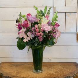 Mixed pink and lavender bouquet in a tall glass vase