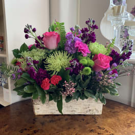 Bright mixed flower arrangement in a rustic white box