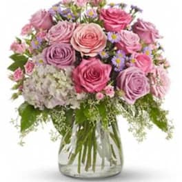 Pink and lavender rose bouquet in a clear glass vase