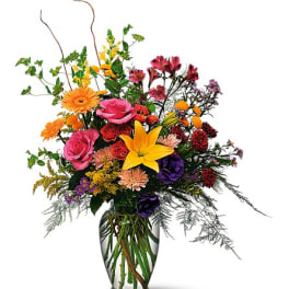 Mixed bouquet of colorful flowers in a clear glass vase