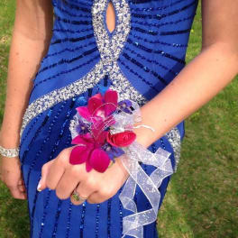Girl in a blue dress wearing a pink flower wrist corsage