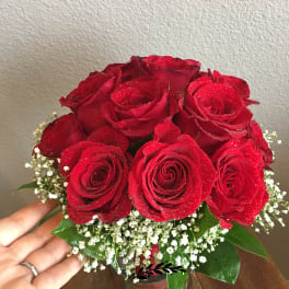 Bouquet of red roses with baby's breath in a glass vase