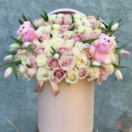 Round box of pale pink and cream roses with two pink teddy bears