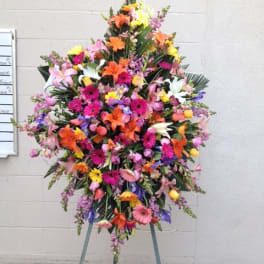 Large standing spray of mixed colorful flowers on an easel
