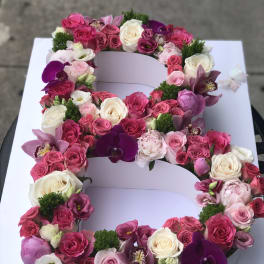 Large floral letter arrangement with pink and white roses and orchids
