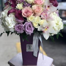 Bouquet of pink, white, and purple flowers in a tall purple vase