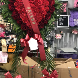 Heart-shaped red rose and carnation standing spray with a ribbon