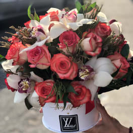 Bouquet of pink roses and white orchids in a white hat box