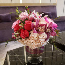 Pink and red floral arrangement in a glass vase