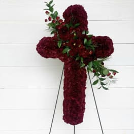 Red floral cross on a stand with green accents