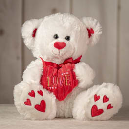 White teddy bear holding a red heart with "LOVE" text