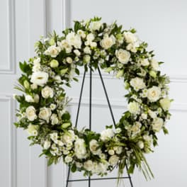 White floral wreath on a black stand