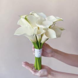 Bouquet of white calla lilies tied with a white band