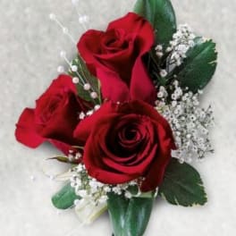 Three red roses with baby's breath and greenery