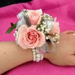 Pink rose wrist corsage with silver ribbon and pearl bracelet