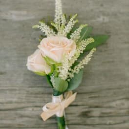 Small boutonniere with pale pink roses and white filler flowers
