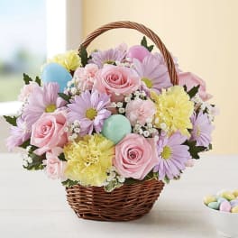 Basket of pastel flowers with decorative eggs