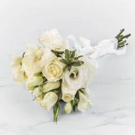 Hand-tied bouquet of white and cream roses and lisianthus wrapped with white ribbon