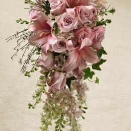 Cascading bouquet of soft pink roses and lilies with trailing white blossoms